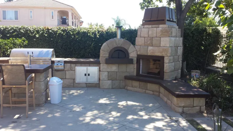 Outdoor kitchen, bar seating and fireplace by Brickhouse Masonry, Central Valley CA